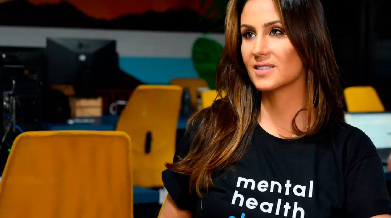 Foto da psicóloga Ana Carolina Peuker, utilizando uma camiseta com os dizeres "mental helth".