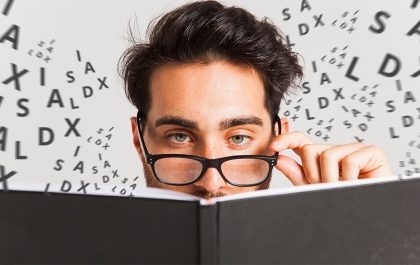 Fotomontagem com um close up no rosto de um homem usando óculos, lendo um livro e, ao fundo, letras embaralhadas flutuando.